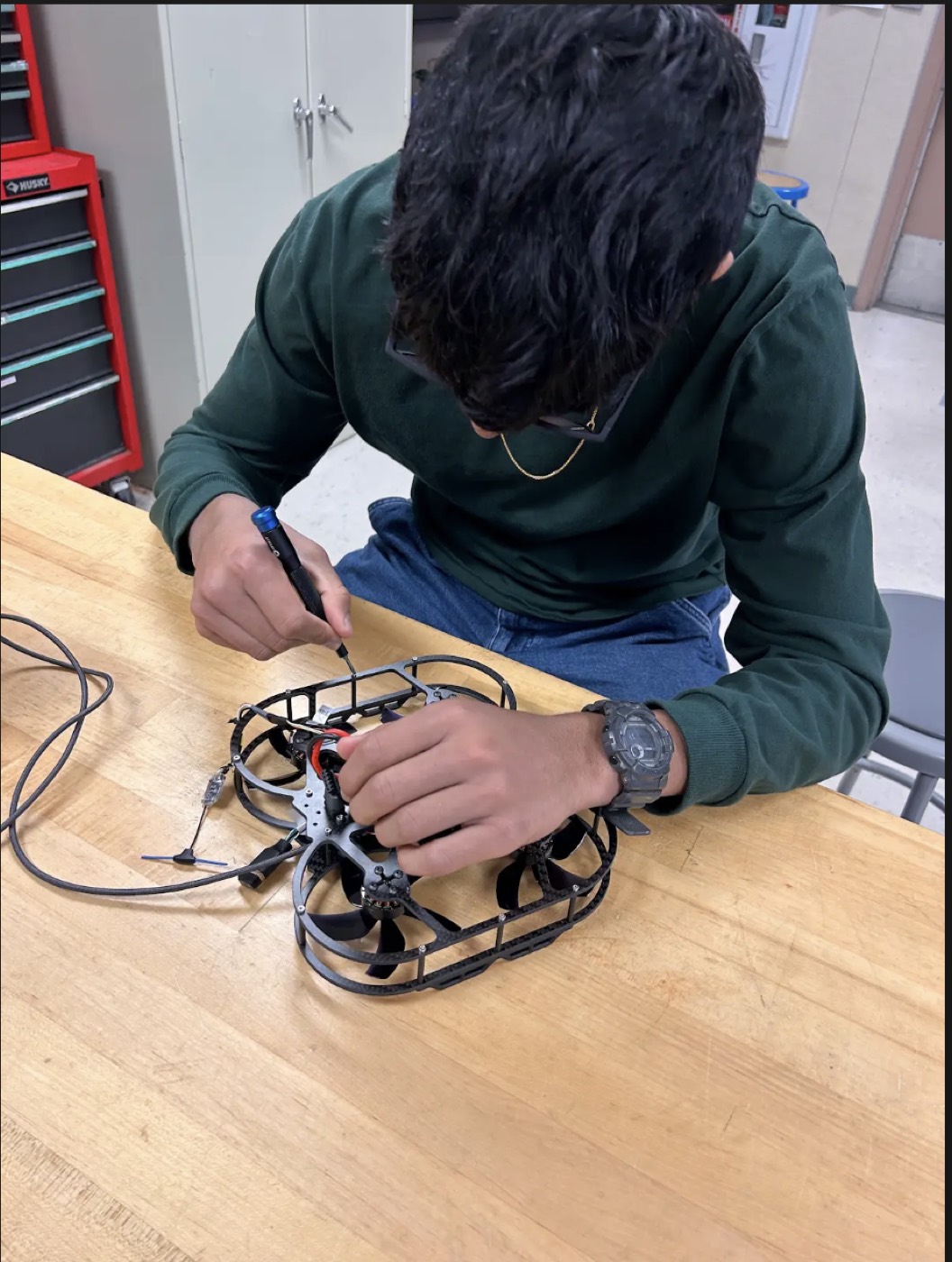 Aakarsh working on the drone assembly at a workbench